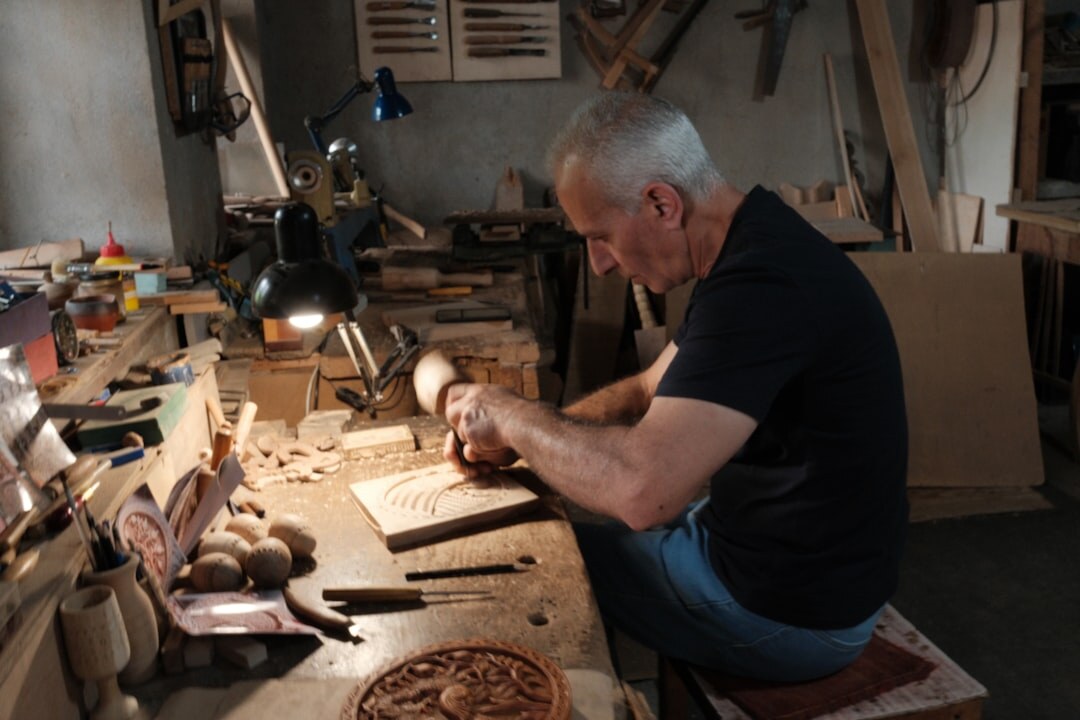 man carving wood sculpture