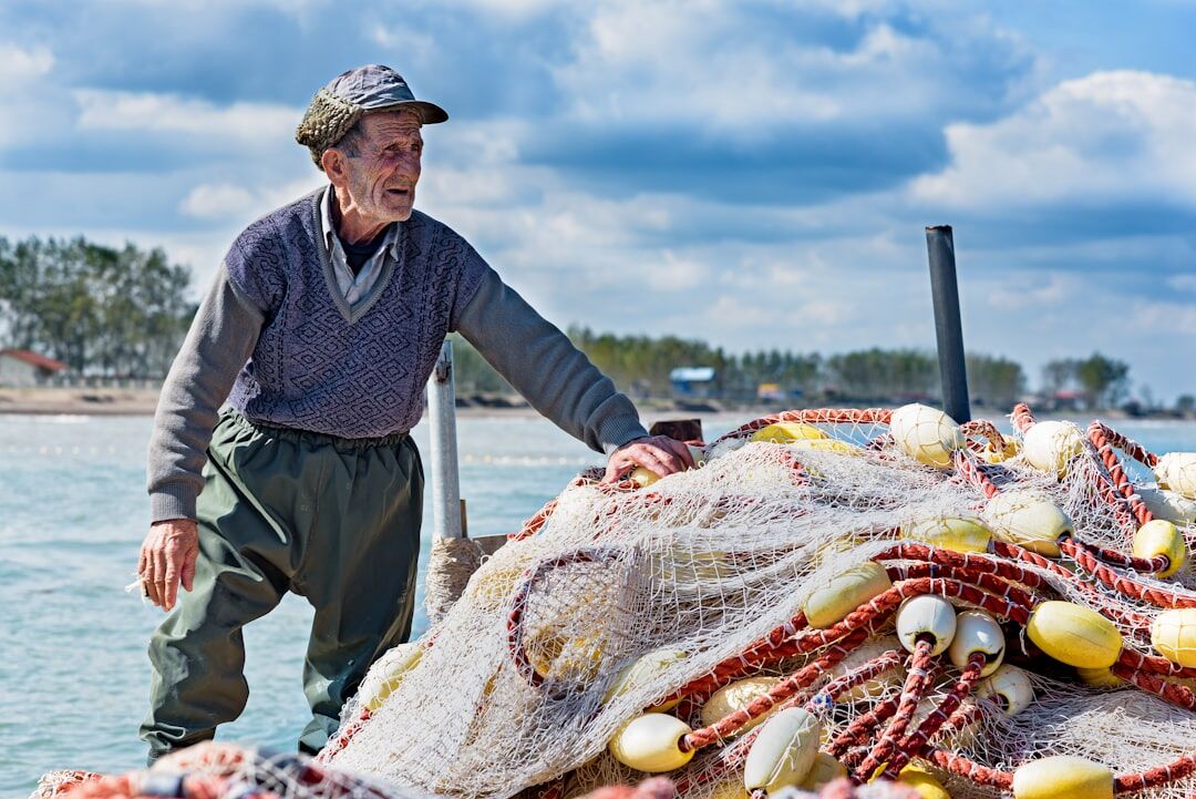 elderly fisherman mending nets